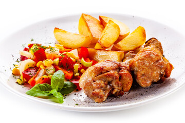 Barbecued chicken drumsticks with fried potatoes and tomato salad on white background
