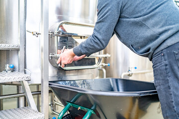 cleaning the boiler from residual malt after brewing beer in the brewery