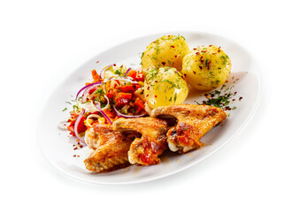Barbecued chicken wings with boiled potatoes and tomato salad on white background