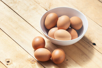  Chicken eggs in white bowl on a wood table