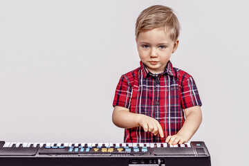 Little boy plays the digital piano. The child likes his hobby. The concept of early childhood development.