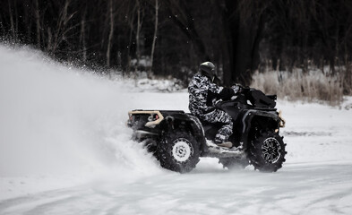 Quad bike rides on white snow in winter. Sport © schankz