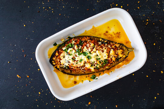 Roasted aubergine stuffed with minced meat and cheese on wooden table
