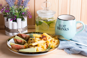 green tea with lime and mint in a glass jar with a plate of country fried potatoes. Homemade food, lunch