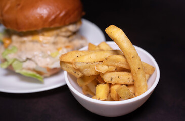 Fresh tasty burger and french fries on black table.