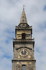Fototapeta na wymiar Close Up of Church Spire and Clock seen against Blue Sky 