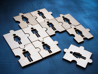 A puzzle with figures and one next to each other as a symbol of a new hire in a team.