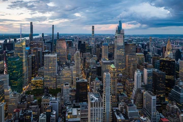 Foto op Aluminium Manhattan An illuminated midtown of New York City and rainy clouds above.