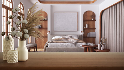 Wooden table, desk or shelf close up with ceramic vases with cotton flowers over japandi cozy bedroom, minimalist style interior design concept