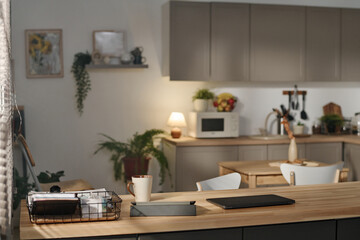 Horizontal image of modern domestic kitchen with gadgets and cup of coffee on table