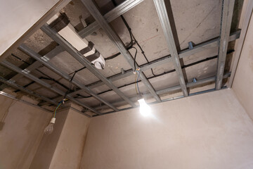 Workers are installing plasterboard (drywall) for gypsum walls in apartment is under construction,...