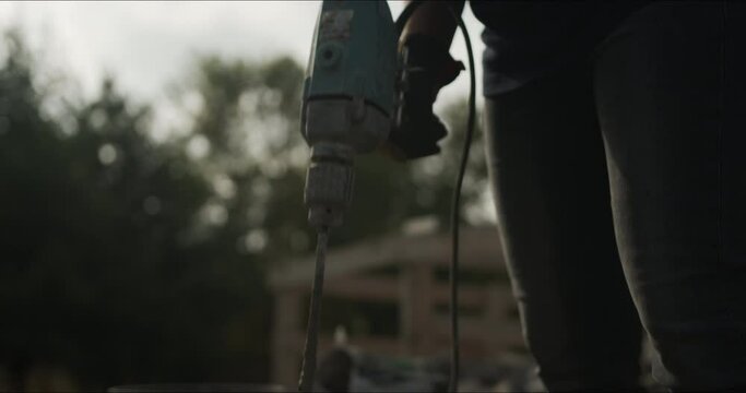 Closeup footage of a person holding a drill for mixing cement on an isolated background