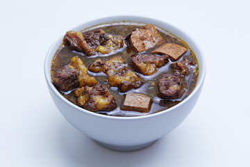 Rawon, Indonesian beef black soup. Originating from Surabaya, East Java. utilizes the black nut Keluak as the main seasoning, which gives a dark color to the soup. isolated white background