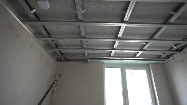 Ceiling installation with expert technicians In the room that is in the construction process.