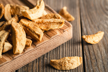 Homemade dried organic apple sliced on wood background.