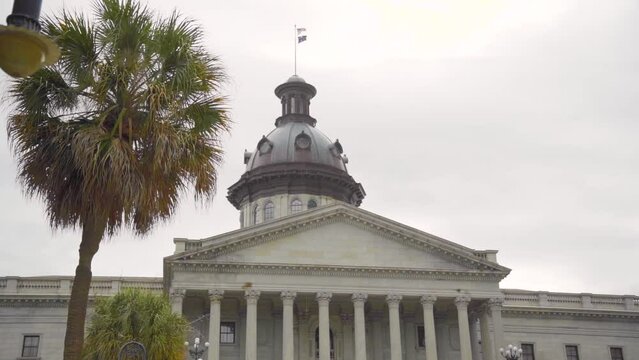 South Carolina State House government building landmark on a cloudy day with palm trees out front in slow motion - close up
