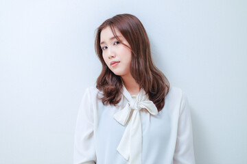 Obraz premium 白いブラウスを着たカメラ目線の若い女性