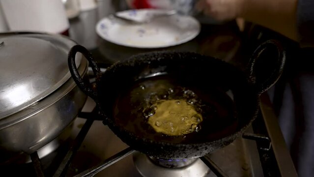 Pouring Handesh Mixture From Cup Into Small Pan Of Hot Oil And Watching Oil Bubble
