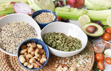 Pumpkin seeds, nuts and chia seeds and other healthy foods on the kitchen table.