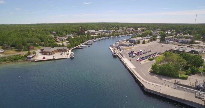 Aerial footage of the harbor of Tobermory with cars and boats by the water, Canada