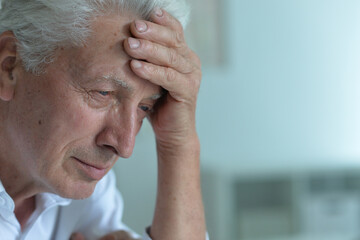 Portrait of sad sick old man with headache