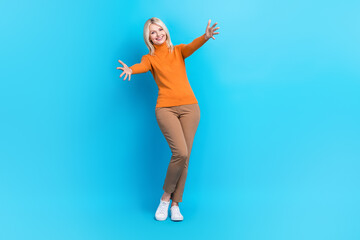 Fototapeta na wymiar Full length photo of satisfied funny woman wear orange sweatshirt catching present stretch arms to you isolated on blue color background