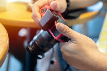 Close up of male hands dressed in yellow T-shirt making setting on display of  camera for cool pictures.