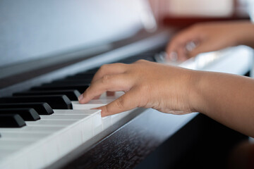 Fototapeta premium Selective focus to kid fingers and piano key to play the piano. There are musical instrument for concert or learning music.