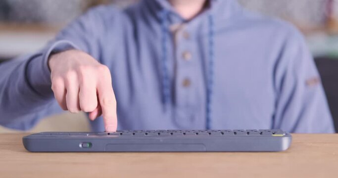 Man repeatedly presses one button with his index finger on computer keyboard. Front view, blue-red flashing light. Concept of programming for dummies, abstraction, cyber criminal, hacker loser.