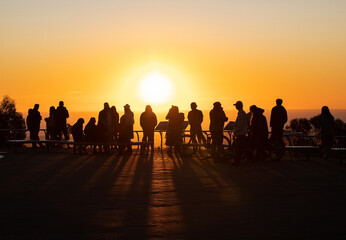 Fototapeta premium Silhouettes of people in sunset contour light, evening orange sun