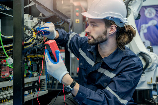 Electrical engineers using measuring them with a multimeter test electrical installations and wiring on protective relays.