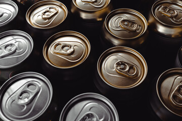 Many closed tin cans of beer or soda. Lots of tin cans. Beer for a party. Ring for tearing off a...