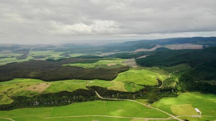 Aerial view of a green field in New Zealand on a cloudy day
