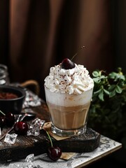Vertical shot of ice coffee with white cream in glass cup on table with cherry next to it