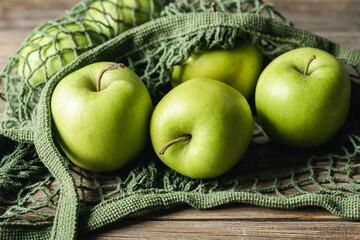 Close-up, green apples in a mesh shopping bag.