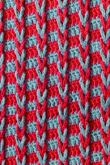 Knitted fabric background. Red blue crochet chain loop braids pattern.