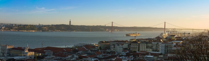 Panoramic shot of the 25 April Bridge and the cityscape at sunset, in Portugal