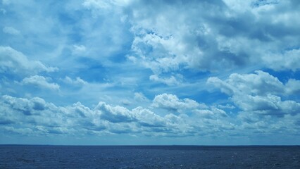 Obraz premium Mesmerizing shot of a seascape under the blue sky and fluffy white clouds