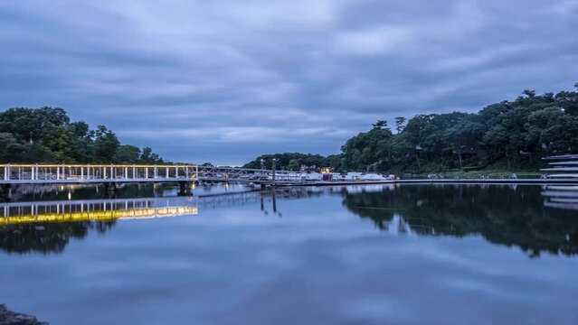 Timelapse of Saugatuck River in Westport Connecticut with still water and moving clouds during blue hour
