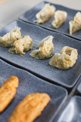 Assorted dim sum appetizers on wooden table background. Set of Chinese food for share. Asian buffet. Traditional Chinese dim sum food. Top view. Different Chinese dumplings on table