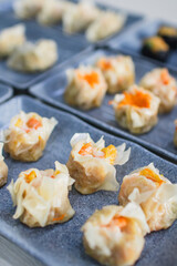 Assorted dim sum appetizers on wooden table background. Set of Chinese food for share. Asian buffet. Traditional Chinese dim sum food. Top view. Different Chinese dumplings on table