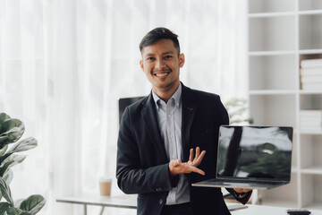 Fototapeta premium Happy working asian businessman talking on the phone with accounting documents at desk in happy working office