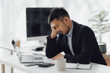 Happy working asian businessman talking on the phone with accounting documents at desk in happy working office