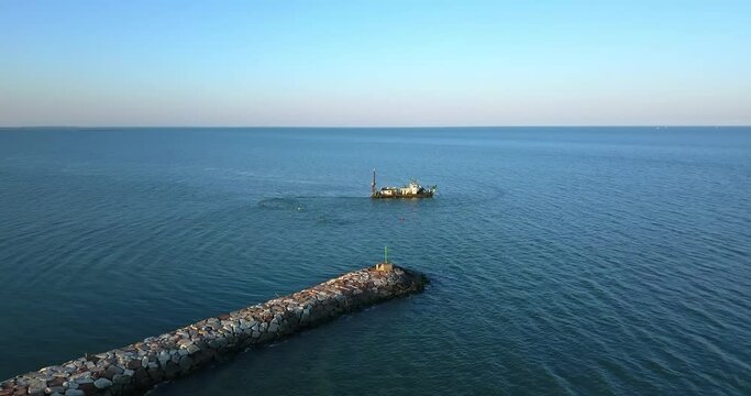 Ship to suck up the sand near a dike