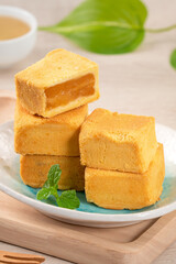 Delicious pineapple cake pastry in a plate on wooden table background with tea.