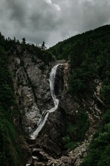 Vertical shot of a narrow waterfall at Marble Mountian, Steady Brook in Newfoundland, Canada