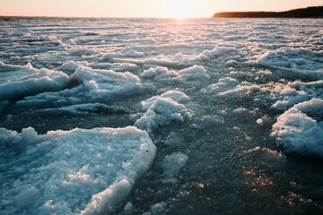 Scenic view of a frozen lake covered with ice at golden hour