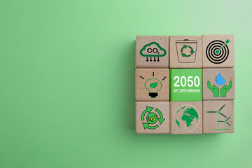Net Zero Emission in 2050,Carbon neutral concept.,Wooden cubes with Net Zero Emission icon over green background with copyspace suitable for environment idea.