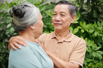 Obraz premium Senior man hugging wife and looking in her eyes