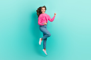 Fototapeta na wymiar Full length photo of cheerful lucky girl wear pink sweater jumping high rising fists isolated turquoise color background